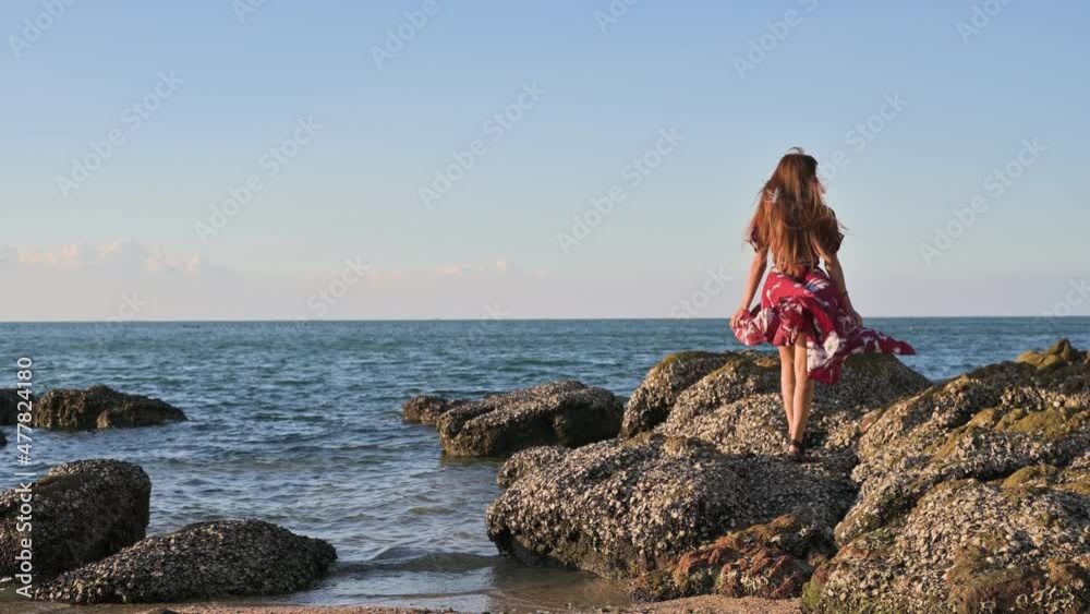 A woman goes for a stroll along the beach in the evening. a pleasant climate A woman goes for a stroll along the beach in the evening. a pleasant climate