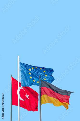 Cover page with national black red yellow flag of Germany, blue with stars EU and red Turkish flag with white crescent moon and star at blue sky background with copy space. Concept of unity solidarity