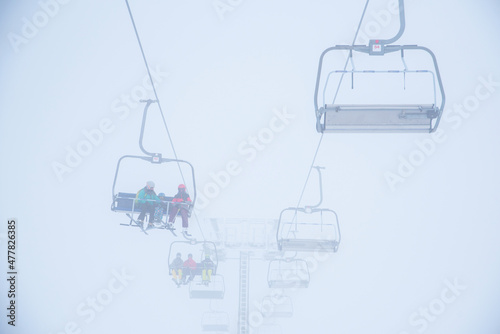 Ski lift in ski resort. Silhouette of skiers, white background