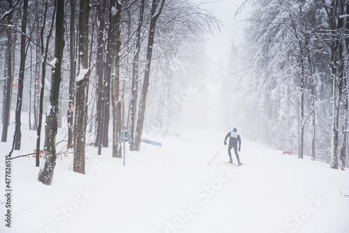A man cross-country skiing on the forest trail