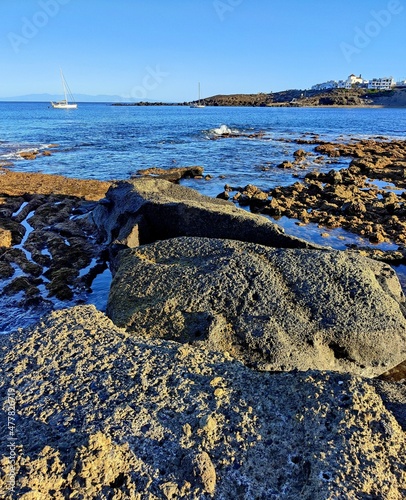 Paisaje costero con barco velero y casas