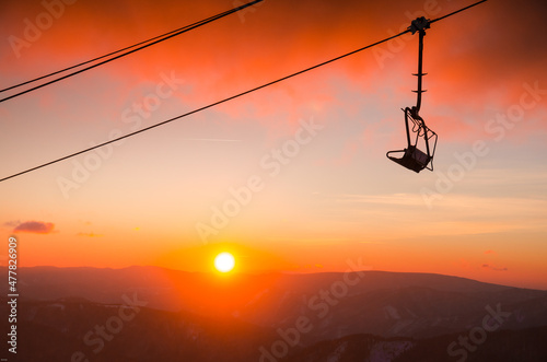 Ski lift cabine in ski resort. Sunrise light in background. Orange edit space for your montage.