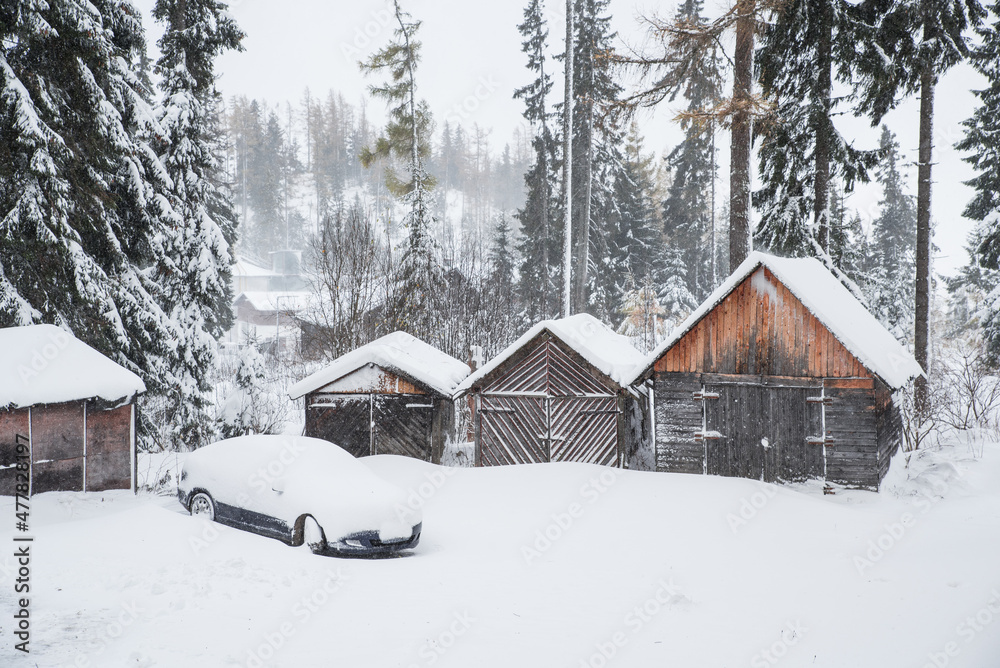 Winter landscape - wooden houses and car under white snow