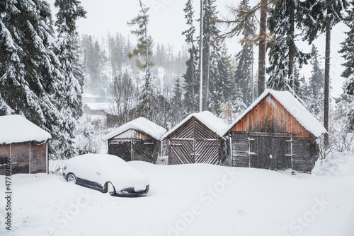 Winter landscape - wooden houses and car under white snow © kovop58