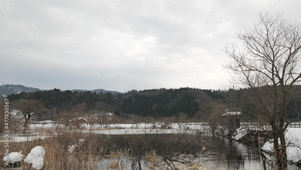 Lake Yogo, Nagahama City, Shiga Prefecture, Japan, in the middle of winter, with mountains and water covered with snow, and withered vegetation. Lake Yogo, Nagahama City, Shiga Prefecture, Japan, in the middle of winter, with mountains and water covered with snow, and withered vegetation.