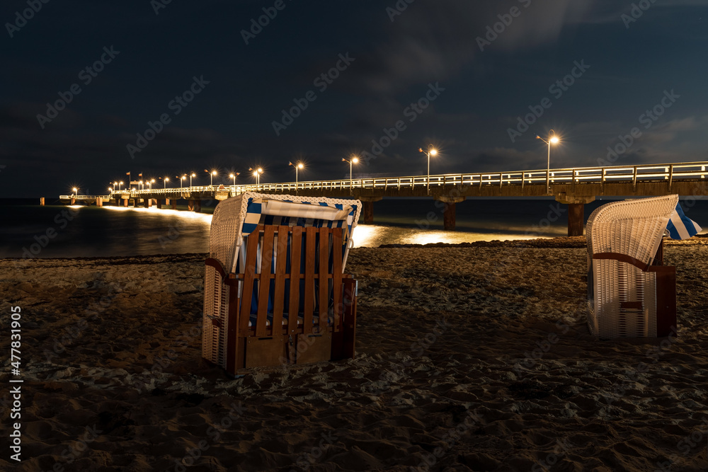 Beach Chairs and the pier after dark, seen in Goehren, Mecklenburg-Western Pomerania, Germany Beach Chairs and the pier after dark, seen in Goehren, Mecklenburg-Western Pomerania, Germany