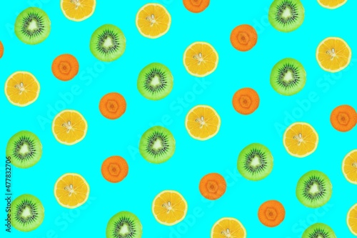 Fruits seamless pattern. Kiwi, lemon and carrot slices isolated on blue background.