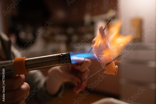 サーモンをガスバーナーで炙る女性の手 photo