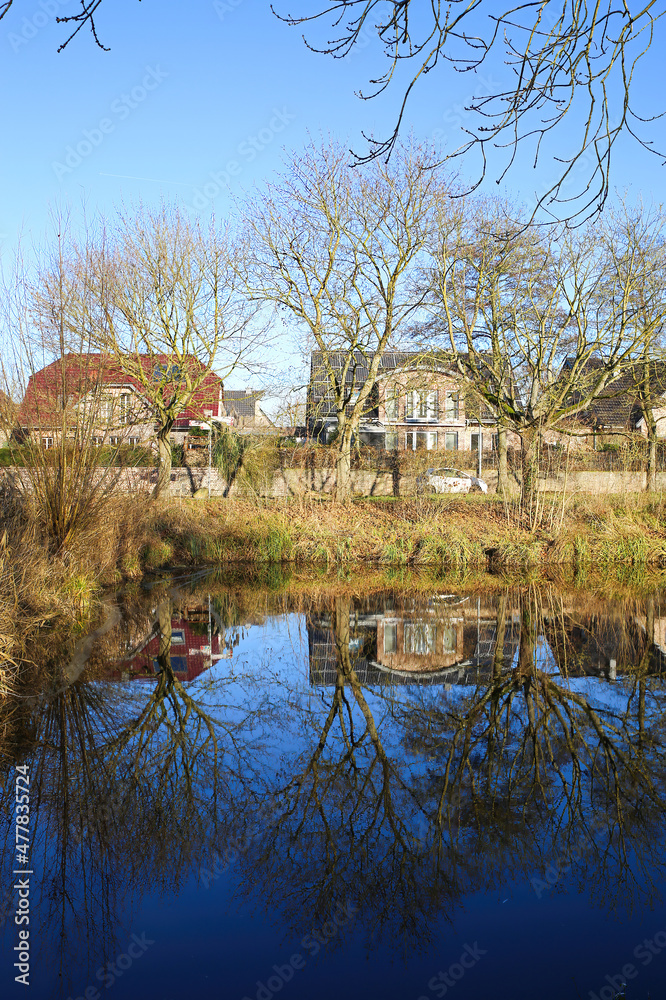 Nettetal (Lobberich), Germany - December 20. 2021: View over lake on waterfront residential houses on sunny winter day Nettetal (Lobberich), Germany - December 20. 2021: View over lake on waterfront residential houses on sunny winter day