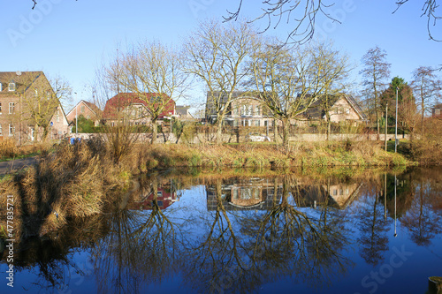 Nettetal (Lobberich), Germany - December 20. 2021: View over lake on waterfront residential houses on sunny winter day photo
