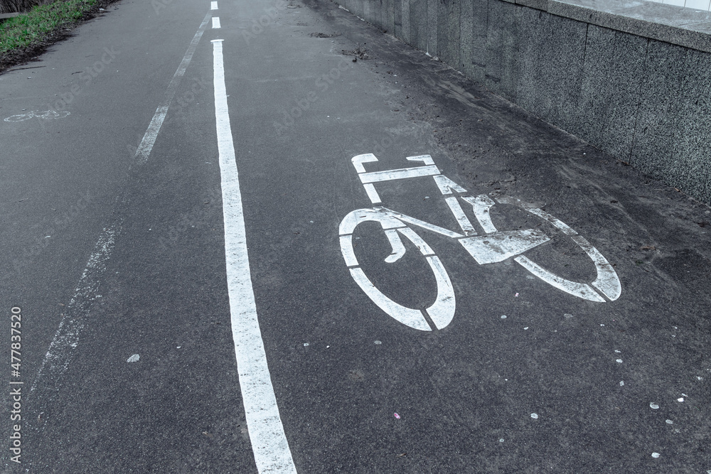 Obraz premium Bicycle lane. Bicycle lane sign on asphalt. Dirty sidewalk with white bike path sign
