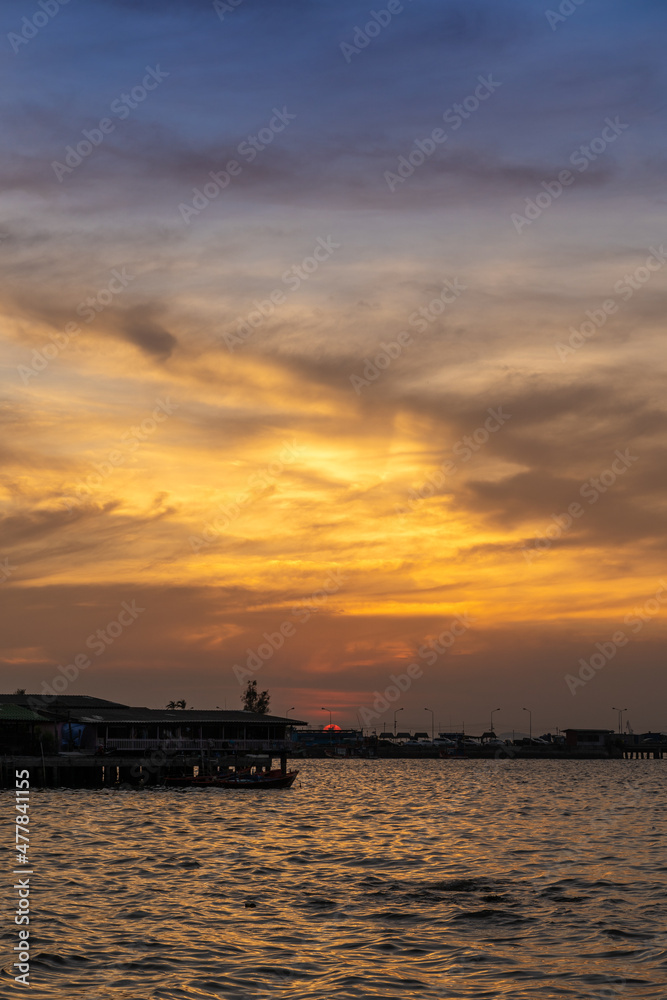 Beautiful sunset over the ocean at Sriracha town in Chonburi, Thailand showing colorful sky and dramatic cloud formations