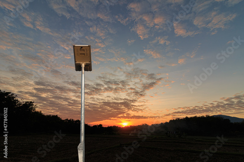 Solar cell street lamp pole on oranges sky with sunset background