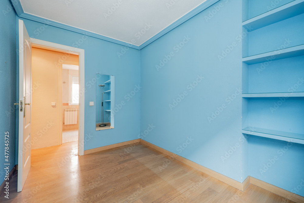 Fototapeta premium bedroom with plasterboard bookshelf and garish blue walls