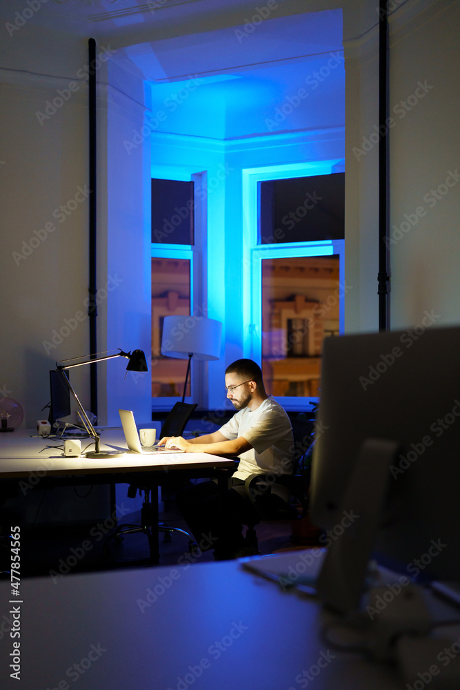 Millennial businessman having video conference call with colleague or partners. Young specialist man work late in office communicate with coworkers remotely on covid-19 quarantine via online meeting