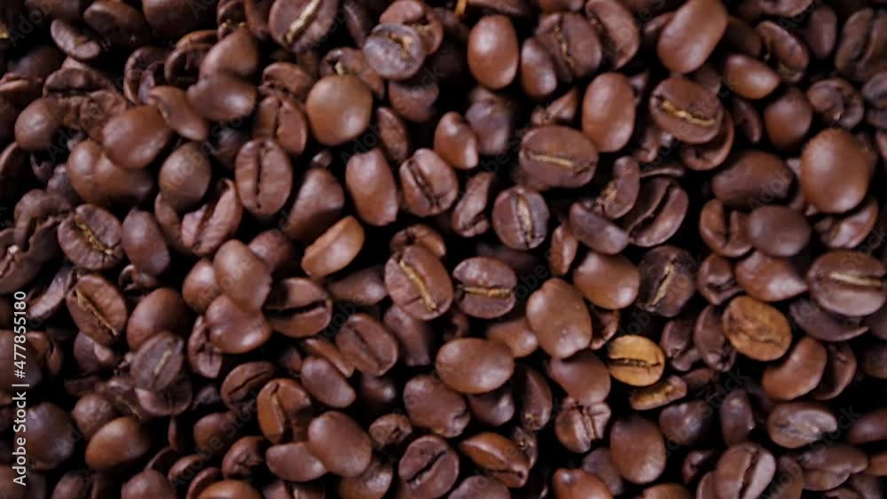 Closeup video of pouring coffee beans, rotating top view roasted brown coffee beans Closeup video of pouring coffee beans, rotating top view roasted brown coffee beans