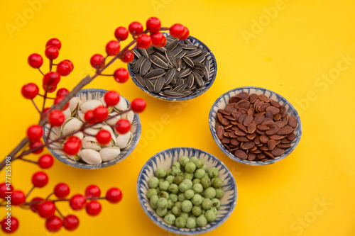 Tet Holiday  Lunar new year  chinese new year concept . Dried sunflower  lotus  watermelon and pumkin seeds top view isolated on yellow. Tet snacks