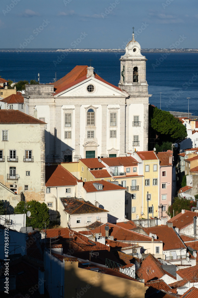 Panoramic view of the Alfama historic neighborhood of Lisbon and the Santo Estevao church at sunset from Portas do Sol viewpoint. Portugal.