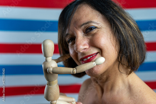 beautiful middle-aged woman shows a wooden jointed puppet