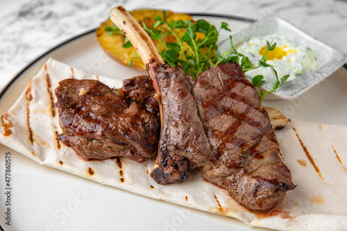Grilled rack of lamb in a festive plate on a marble background. Restaurant banquet menu.