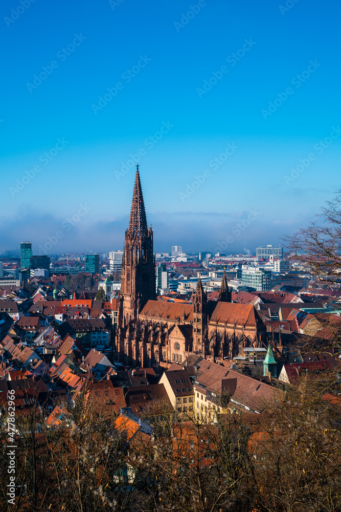 Germany, Freiburg im Breisgau cityscape, muenster cathedral in winter misty atmosphere, aerial panorama view above at sunset