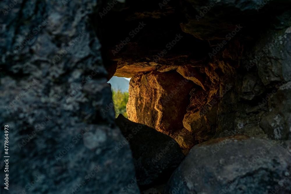 hole in a stone wall through which the outside world is visible