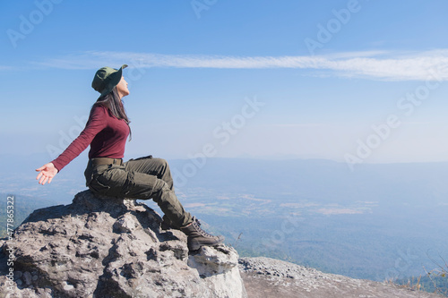 Tourist girl sitting on the big stone with beautiful bluesky  at  Phugradung National park Thailand. photo