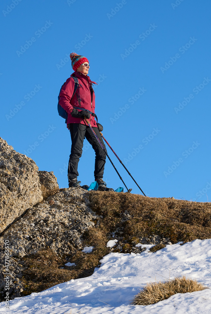 nice and active senior woman snowshoeing in  in the Allgau alps above Immenstadt, Bavaria, Germany 