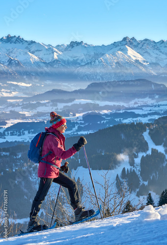 nice and active senior woman snowshoeing in in the Allgau alps above Immenstadt, Bavaria, Germany 