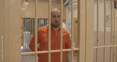 the prison guard leads the prisoner to the door