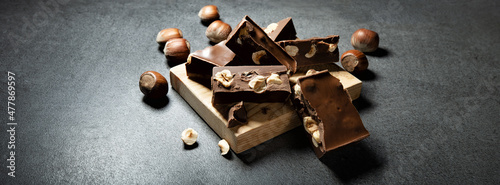 Gianduia nougat with chocolate and hazelnuts on dark gray background, space for text.. photo