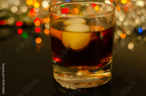 Drink Cuba Libre, rum with cola in an old fashoned glass with two ice balls photo