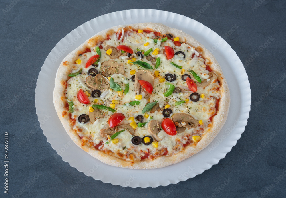 Delicious homemade Italian pizza with tomatoes and pea pods, corn olives, mushrooms and tomatoes. Top view close up