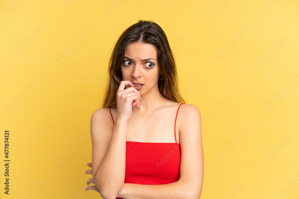 Fototapeta premium Young caucasian woman isolated on yellow background nervous and scared