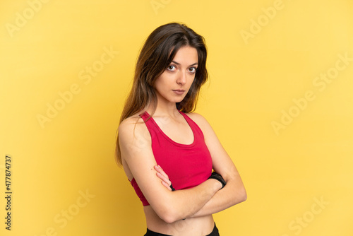 Young caucasian woman isolated on blue background keeping the arms crossed