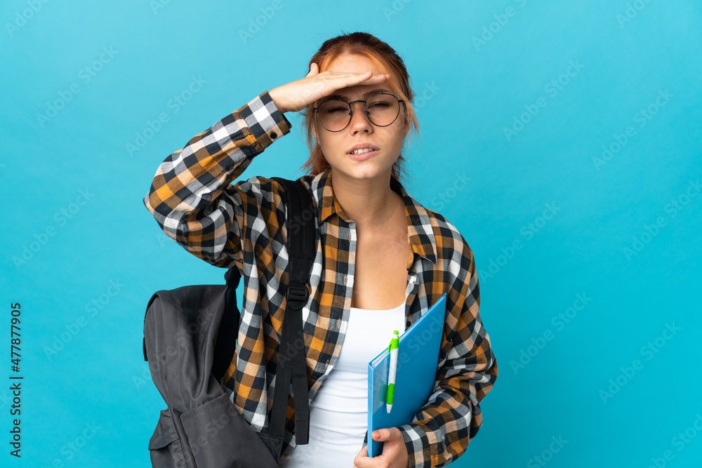 Teenager student Russian girl isolated on blue background looking far away with hand to look something Teenager student Russian girl isolated on blue background looking far away with hand to look something