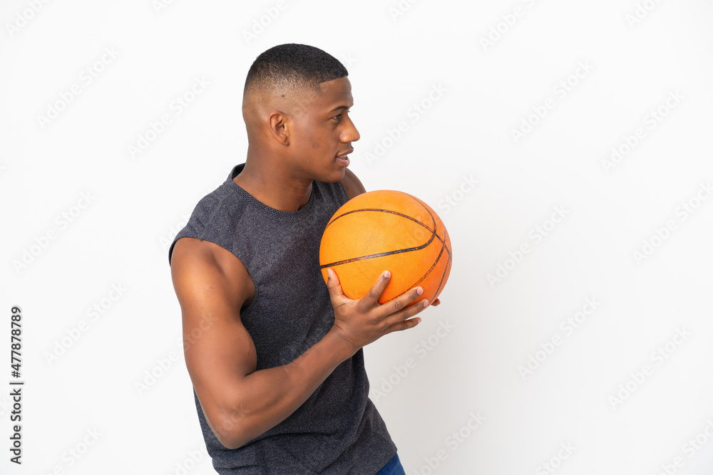 Young latin man isolated on white background playing basketball