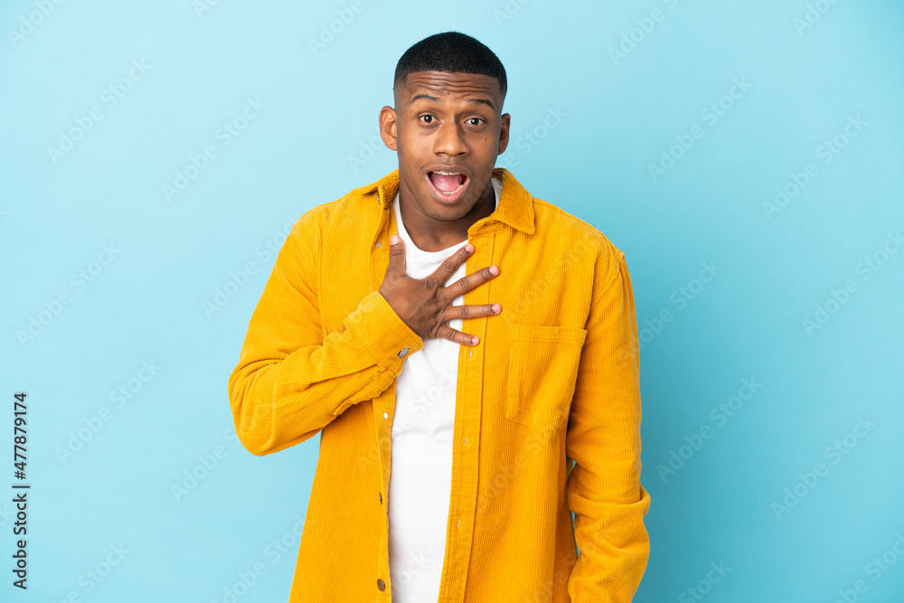 Obraz premium Young latin man isolated on blue background surprised and shocked while looking right