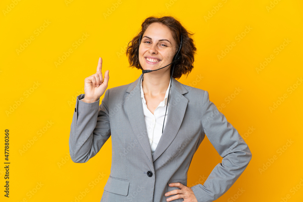 Young English woman isolated on yellow background showing and lifting a finger in sign of the best Young English woman isolated on yellow background showing and lifting a finger in sign of the best