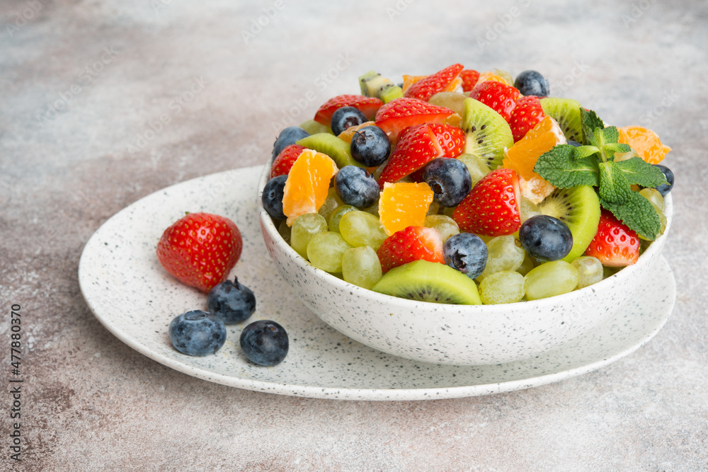 Fruit salad of blueberries, strawberries, grapes and kiwi in a plate