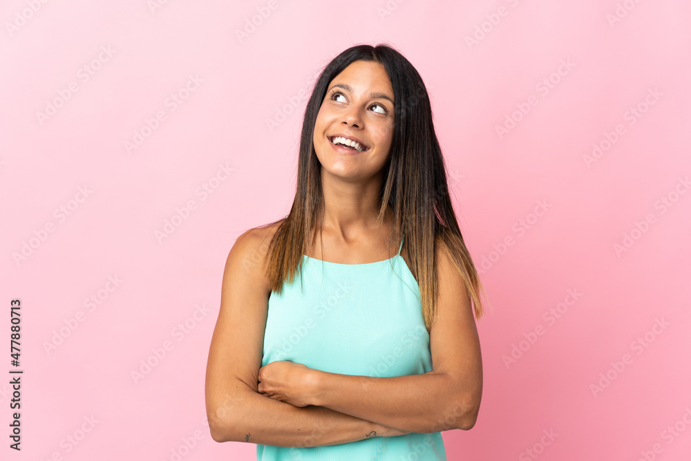 Caucasian girl isolated on pink background looking up while smiling Caucasian girl isolated on pink background looking up while smiling