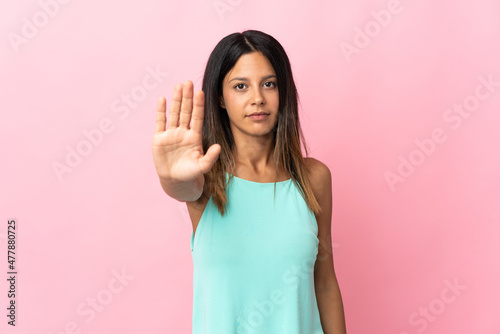 Caucasian girl isolated on pink background making stop gesture