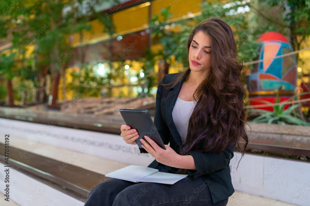 Obraz premium Young attractive business woman using a digital tablet indoor