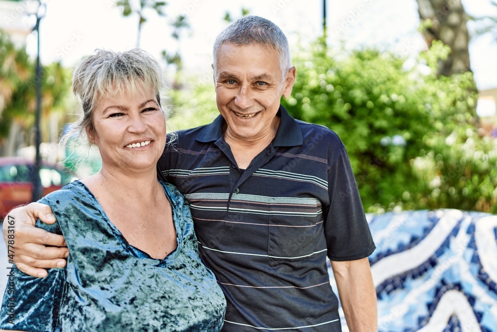 Naklejka premium Middle age caucasian couple of husband and wife together on a sunny day outdoors. Smiling happy in love hugging at the city.