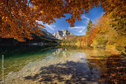 Fototapeta Naklejka Na Ścianę i Meble -  An amazing autumn scenery from Austrian Alps. Beautifully colored trees, blue sky, mountain top and all this mirrored in crystal clear lake. Breathtaking view. Travelling, exploring, relaxing.