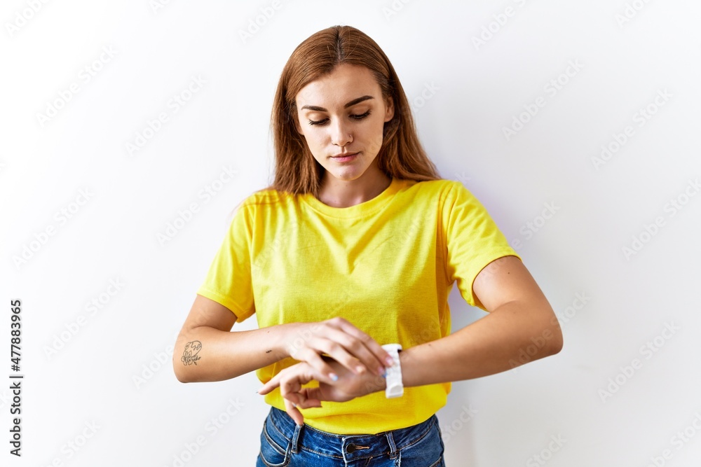 Young brunette woman standing over isolated background checking the time on wrist watch, relaxed and confident Young brunette woman standing over isolated background checking the time on wrist watch, relaxed and confident