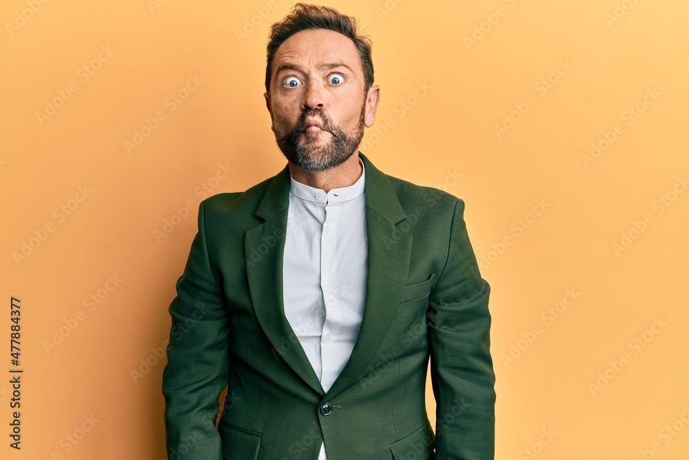 Middle age man wearing business suit making fish face with lips, crazy and comical gesture. funny expression. Middle age man wearing business suit making fish face with lips, crazy and comical gesture. funny expression.