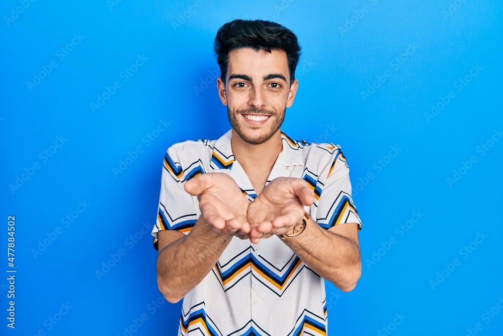 Young hispanic man wearing casual clothes smiling with hands palms together receiving or giving gesture. hold and protection Young hispanic man wearing casual clothes smiling with hands palms together receiving or giving gesture. hold and protection