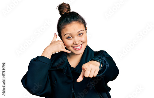 Konstfotografi Young hispanic girl wearing sportswear smiling doing talking on the telephone gesture and pointing to you