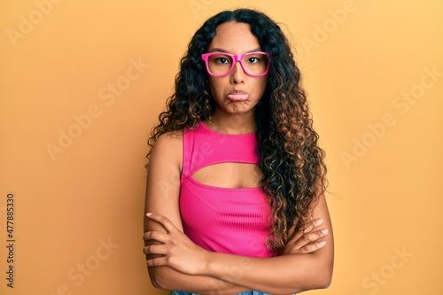 Young latin woman wearing casual clothes and glasses depressed and worry for distress, crying angry and afraid. sad expression.